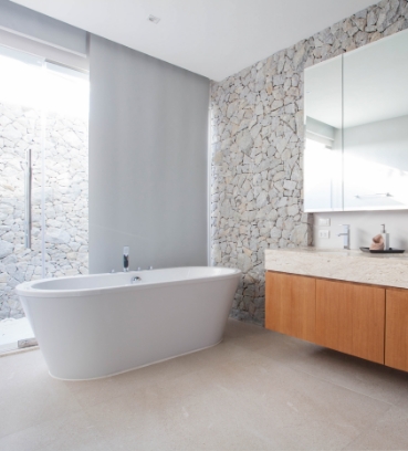 Modernes Badezimmer mit freistehender Badewanne und rustikaler Wandgestaltung